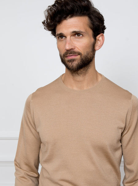 Man wearing light camel long sleeved crewneck sweater knit in 100% luxury and premium merino wool.